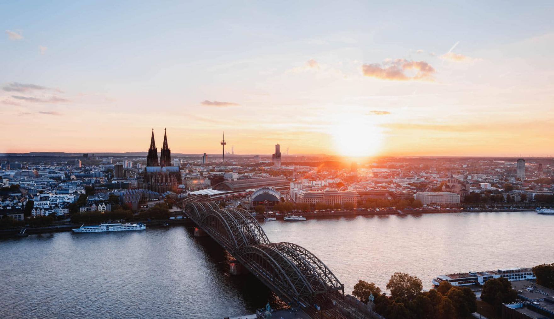 Sonnenuntergang fotografiert von der linken Rheinseite. Man sieht den Kölner Dom und die Hohenzollernbrücke.