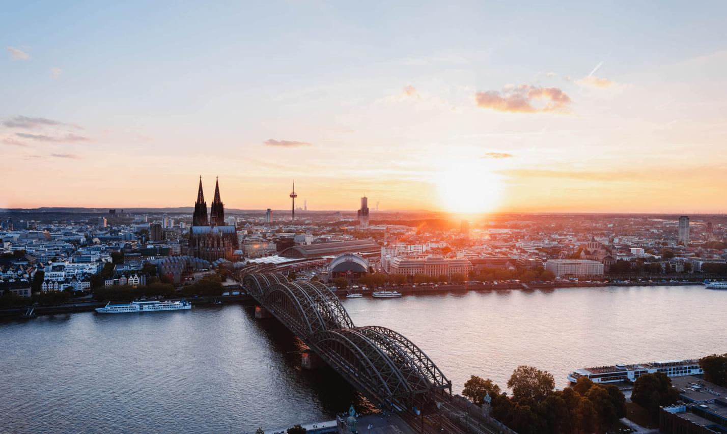Sonnenuntergang fotografiert von der linken Rheinseite. Man sieht den Kölner Dom und die Hohenzollernbrücke.