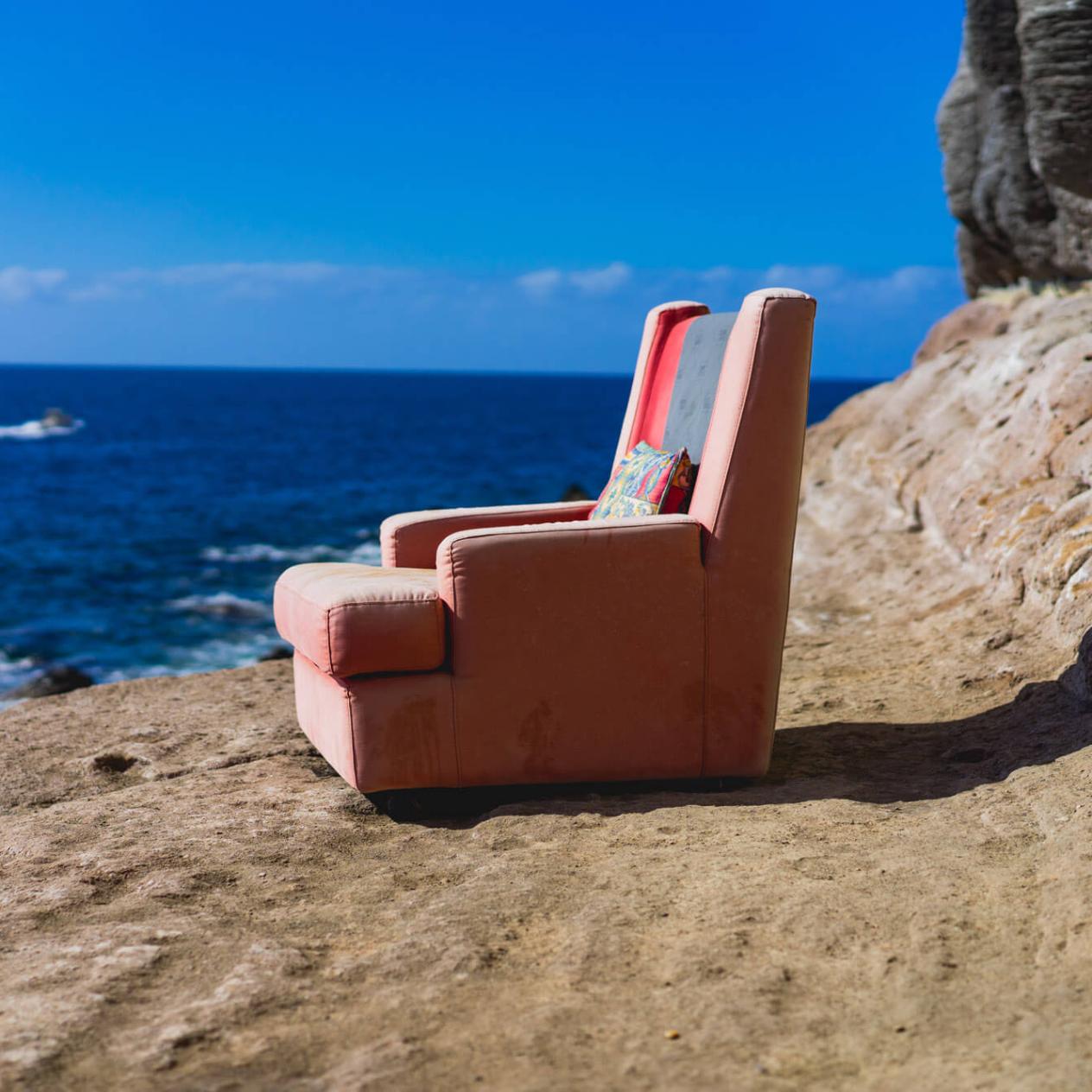 Ein einsamer Sessel steht am Meer