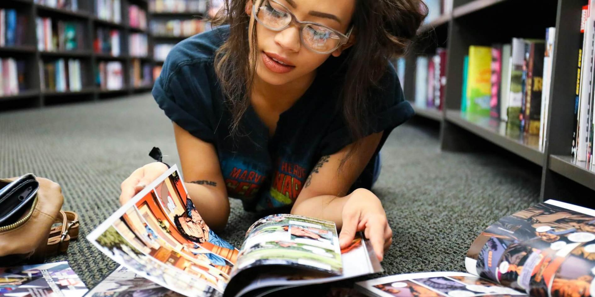 Eine junge Frau liegt auf dem Boden und liest Bücher